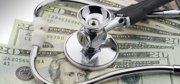 Image of a stethoscope on top of a stack of cash.