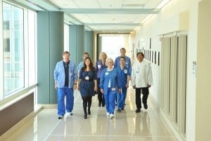 Group of medical professionals walking down the hallway of hospital.