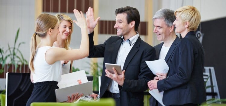 Group of professionals celebrating with high fives.