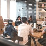 Group of coworkers sitting and laughing at a large table.