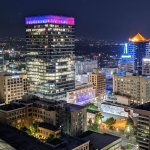 View of a vibrant city from a rooftop at night.