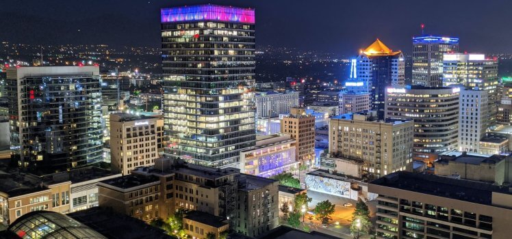 View of a vibrant city from a rooftop at night.