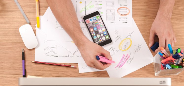 Overhead view of a man marking papers with a highlighter.