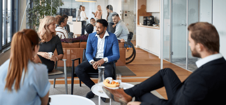 Group of workers gathered in an open working space with class walls.