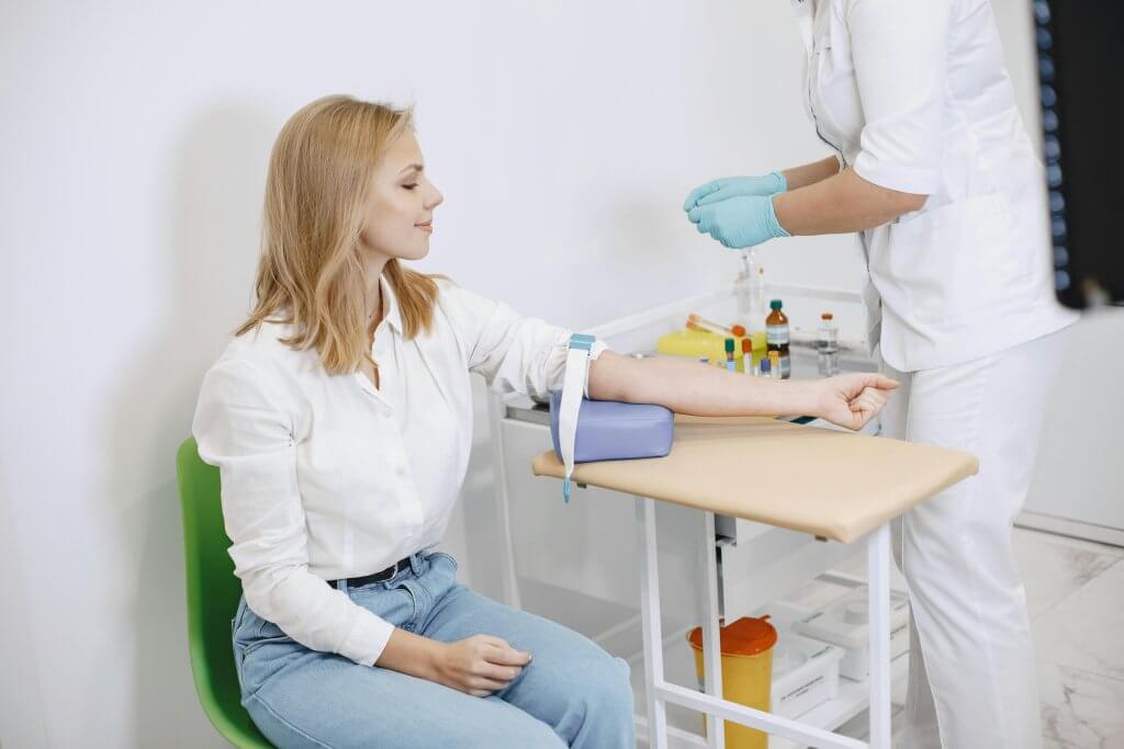 Woman at a clinic having her blood drawn for part of the wellness at work program.