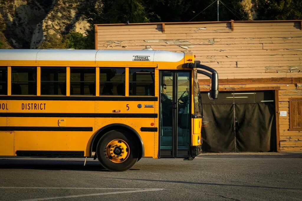 A school bus on the road being driven by a participant in the school wellness program.
