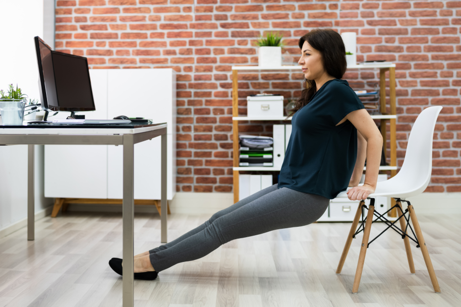Employee performing a desk exercise at work, demonstrating how inclusive wellness programs support accessible, adaptable health habits for all employees.