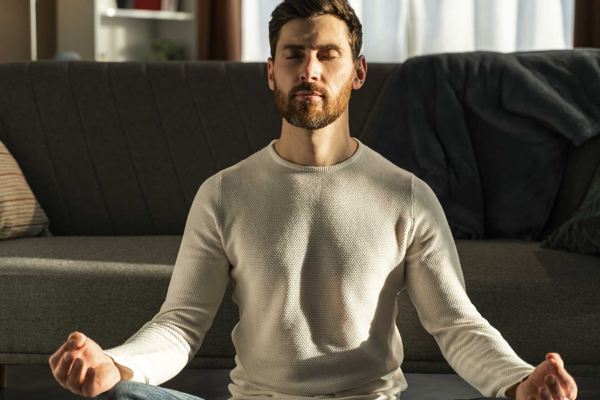 man meditating in front of couch<br />
